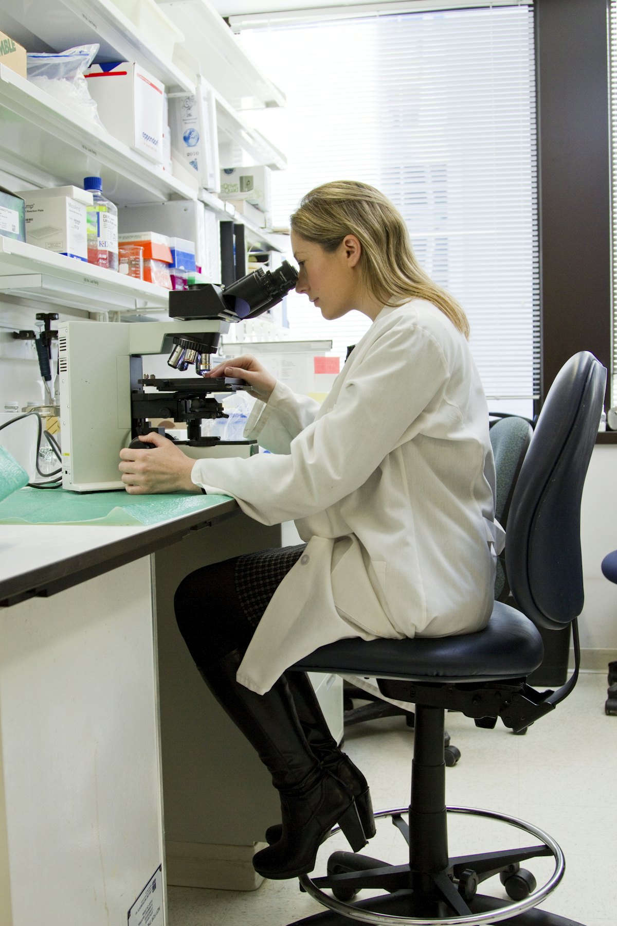 Scientist reviewing samples through a microscope